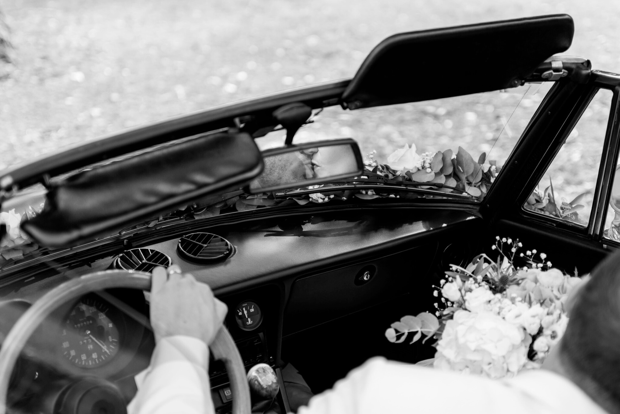 wedding couple photographed kissing in the rearview mirror sitting in oldtimer car at wedding at Spiegelsaal Aschaffenburg
