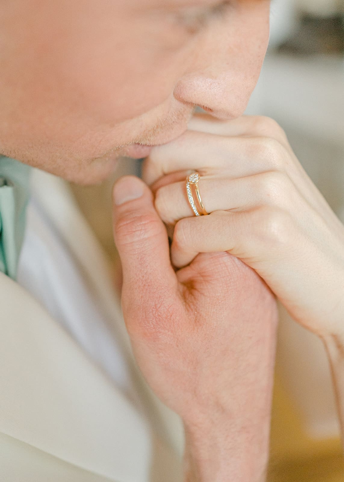 Braeutigam küsst Hand der Braut Fokus auf Ehering und Verlobungsring der Braut