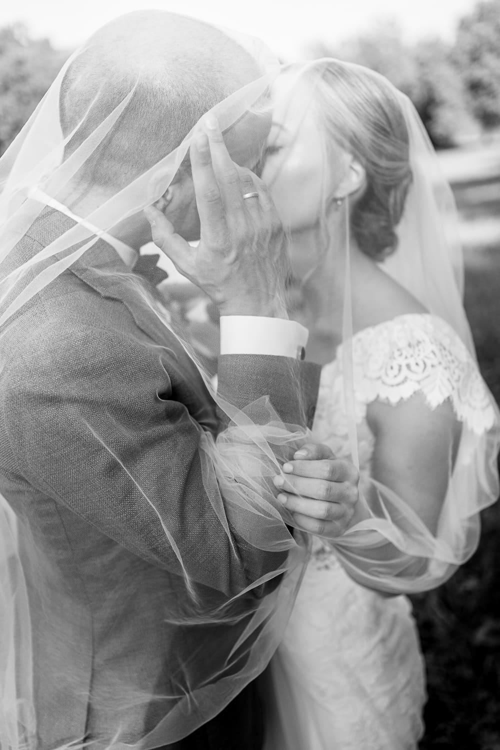 Wedding couple kissing under veil