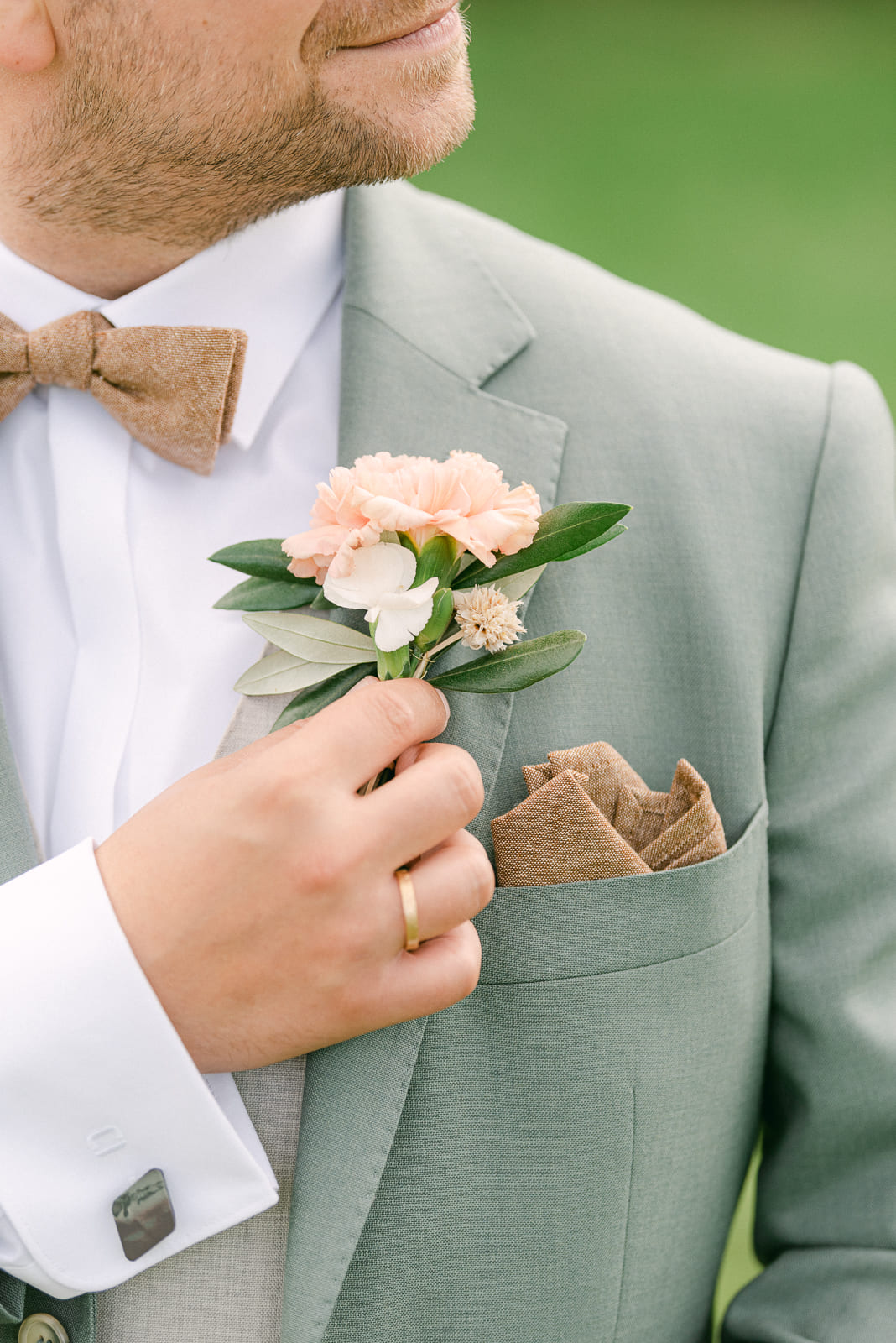 Detail photo bridegroom wedding ring and boutonniere pin